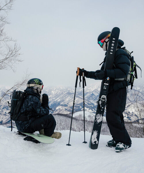 A skier and snowboarder on the top of a mountain