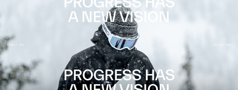 White "Progress Has A New Vision" text over a snowboarder with white revolt pro goggles