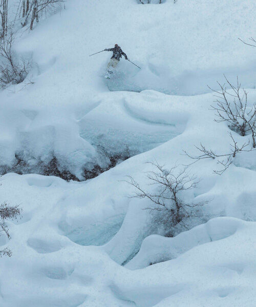 Skier going down a snowy mountain representing the all mountain riding style