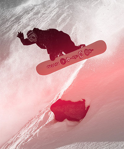 Snowboard rider jumping in the slopes